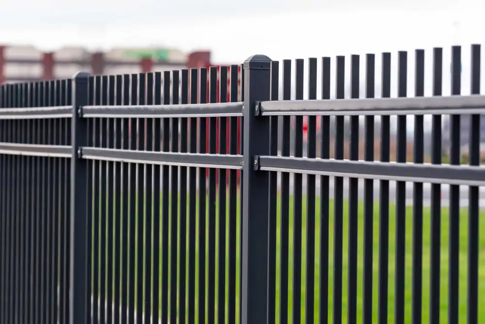 Close-up of black aluminum fence pickets and rail