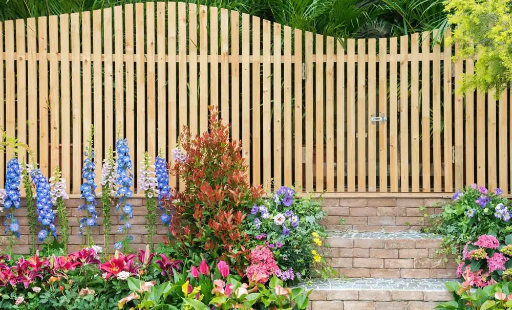 Cedar garden fence with an arched top section and plantings along the base
