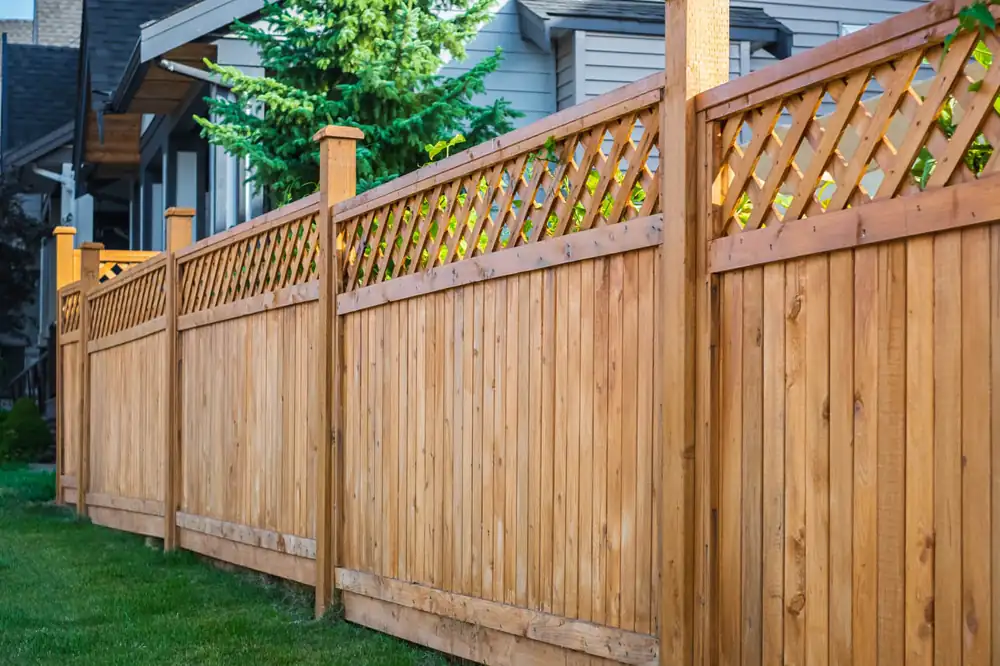 Cedar privacy fence with a lattice top section along a backyard